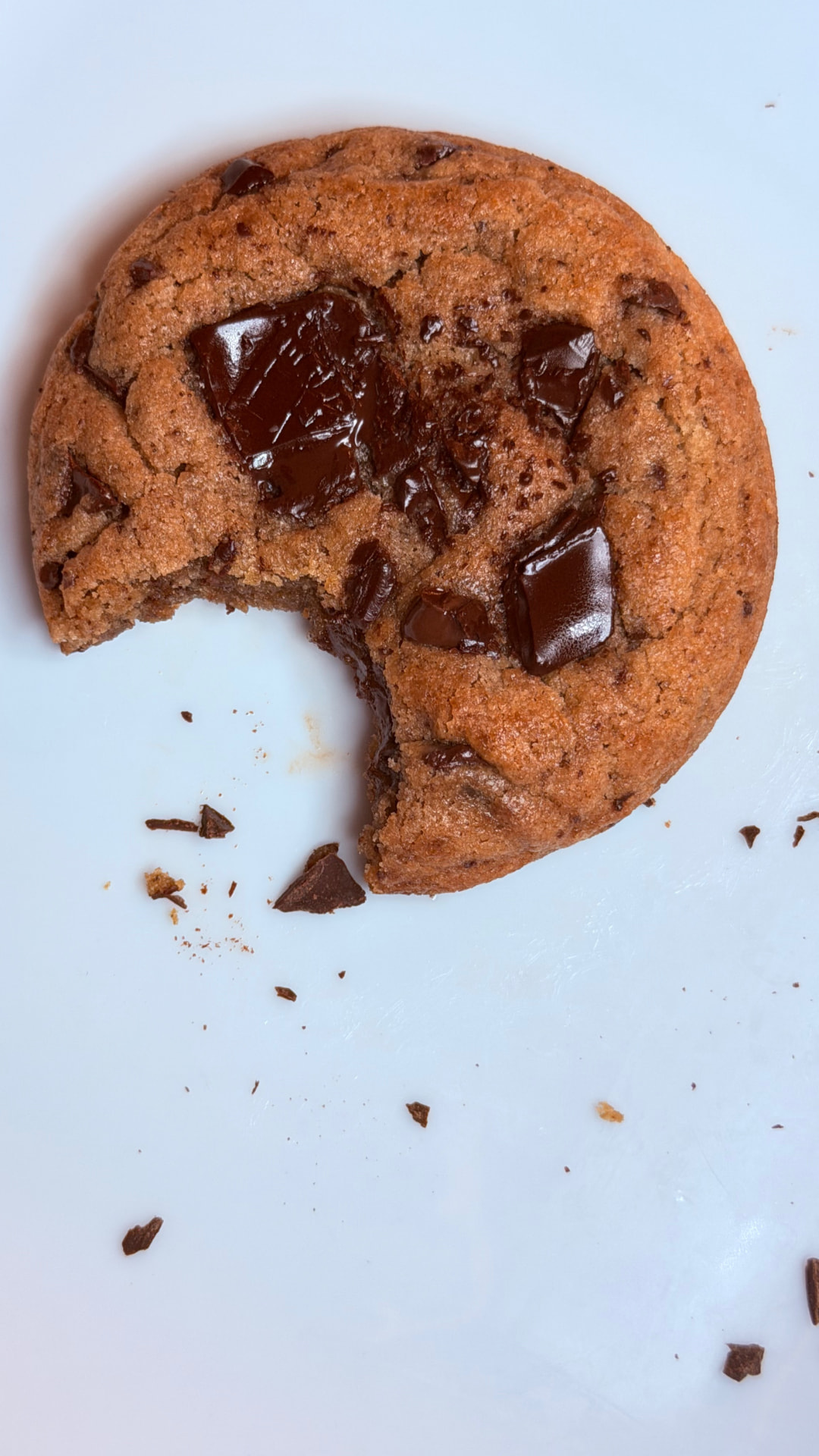 Chocolate chunk cookie with a bite taken out, showing melted chocolate chunks
